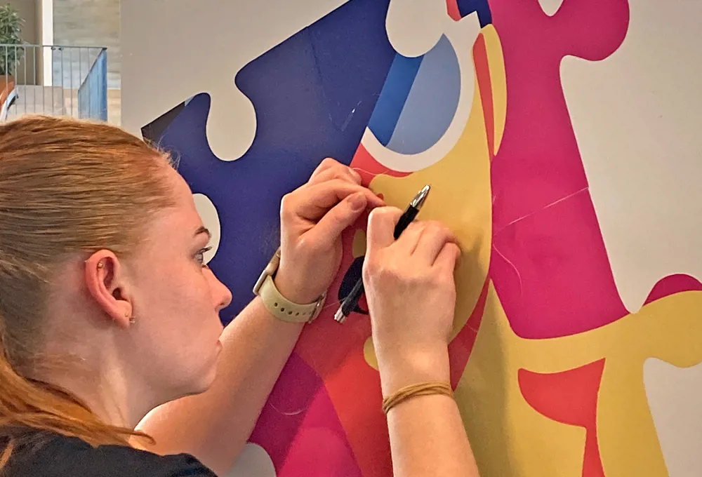 Skiltetekniker arbejder med folie på et skilt