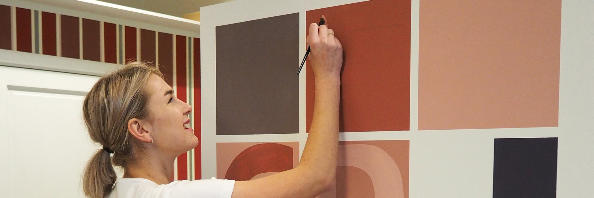 Bygningsmaler bruger lille pensel til at male bogstav