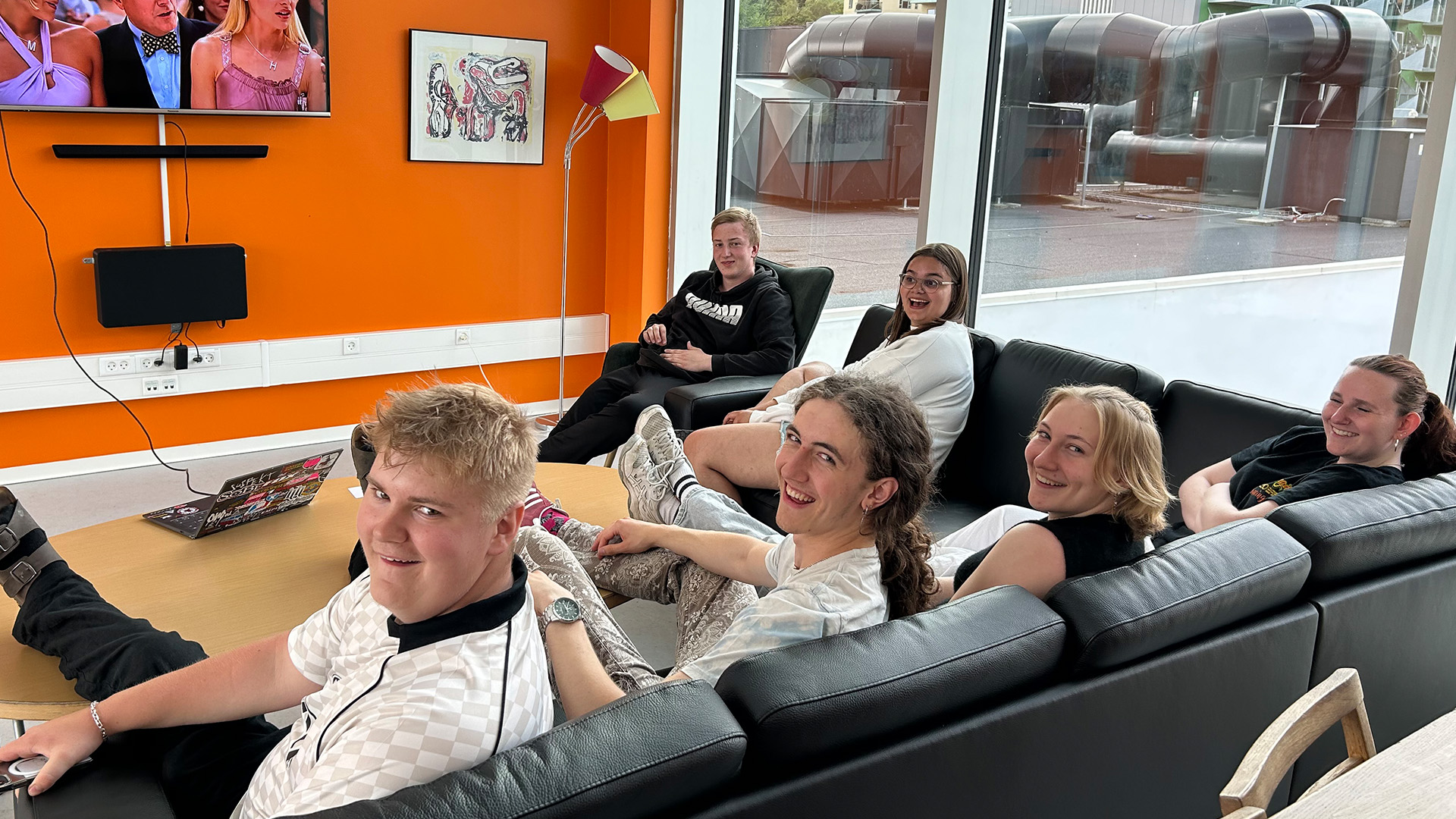 EUD eleverne sidder i fællesrummet i studieboligen på sofaen ved fjernsynet
