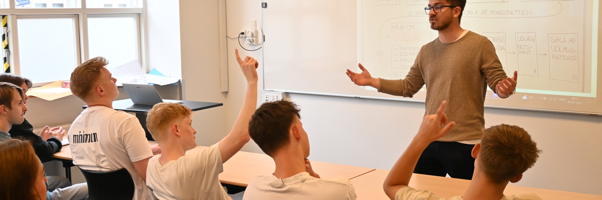 En elev rækker hånden i klassen under undervisningen