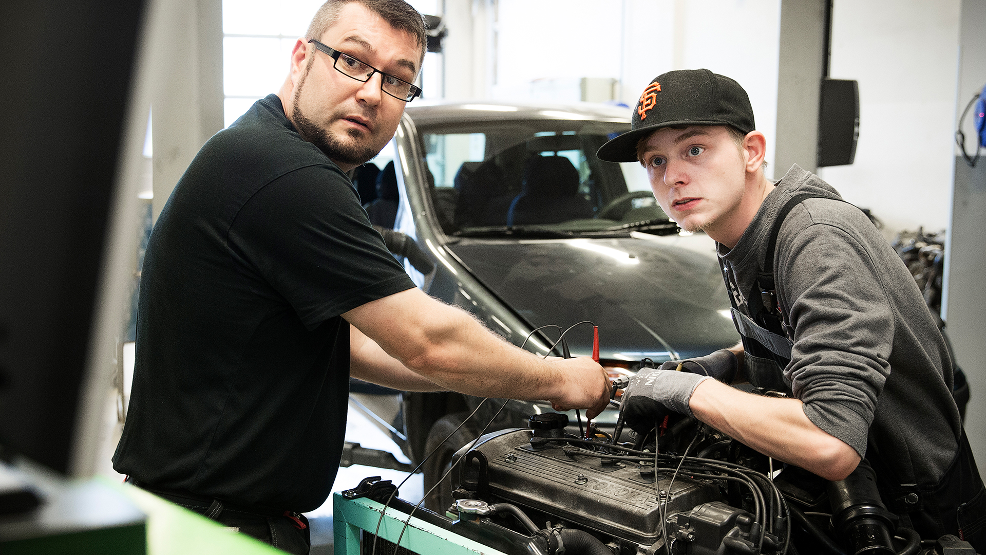 Lærer og elev arbejder på motor