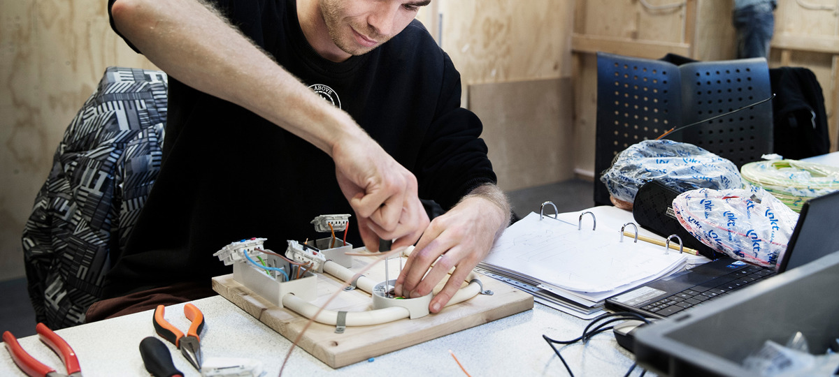 Elektriker skruer i elinstallation på et bord