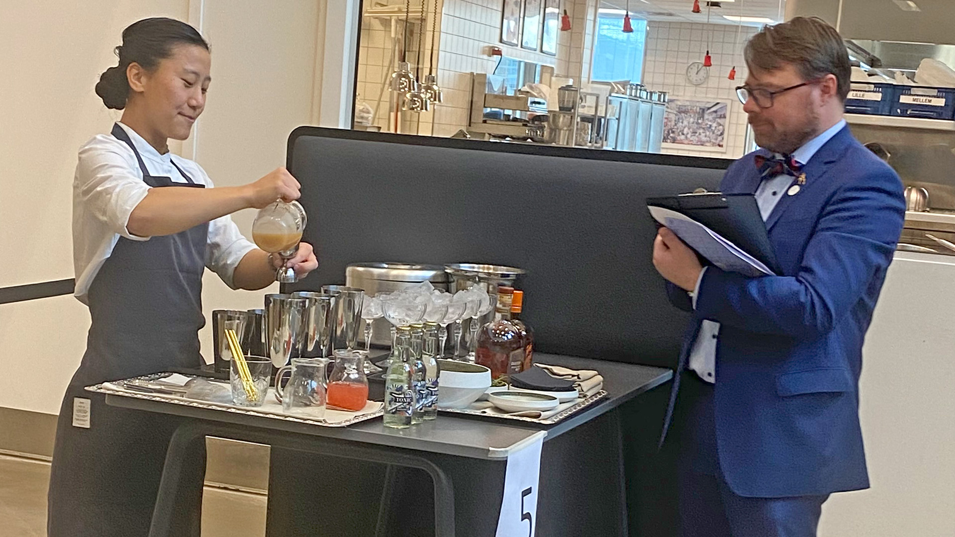 Tjenerelev bliver bedømt af dommer ved Young Chef konkurrence